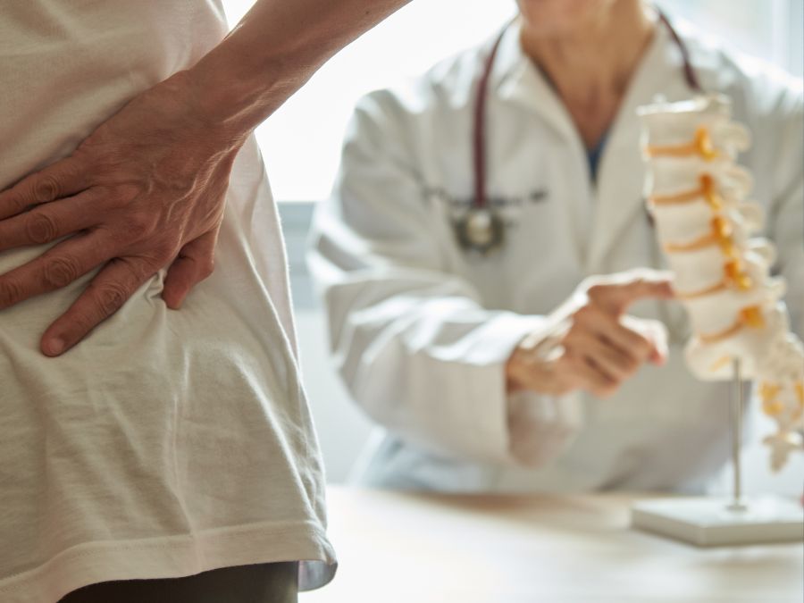 Medico spiega a un paziente le differenze tra chirurgia per ernia del disco e ozonoterapia RX guidata